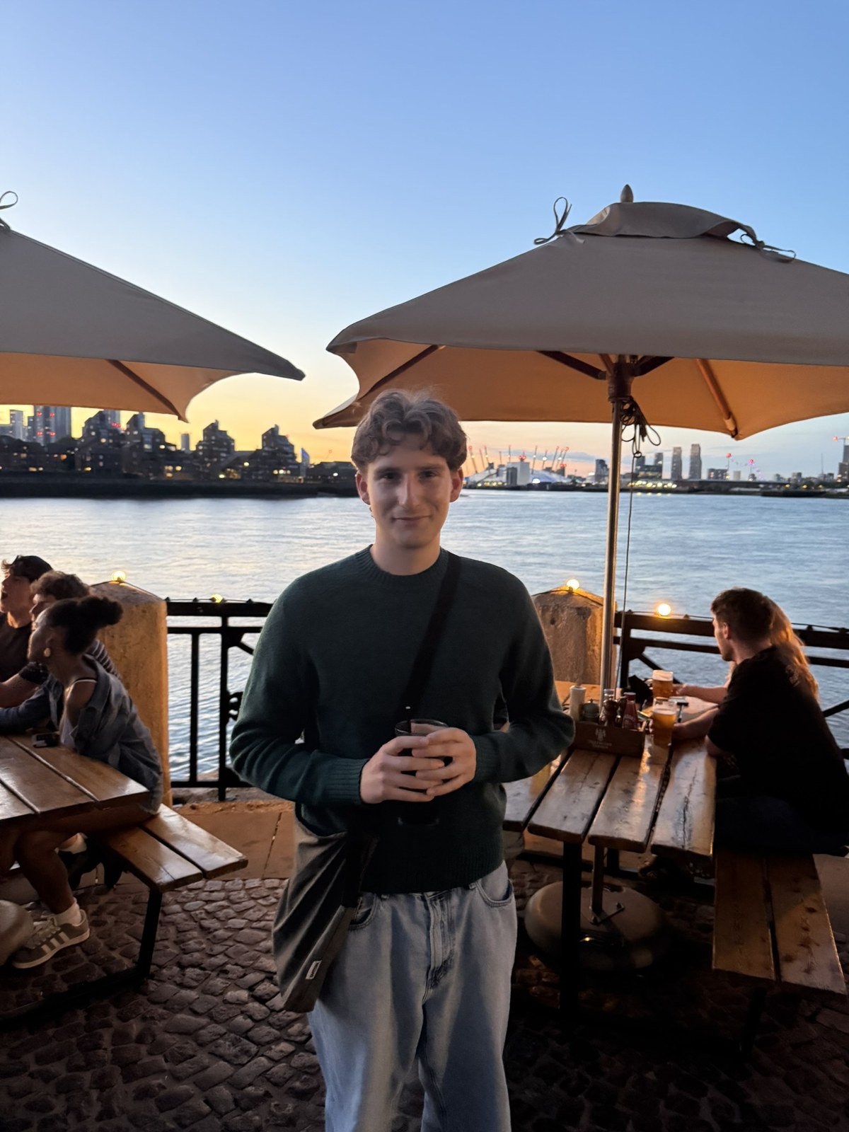 An Ardenmere employee standing beside the river at sunset